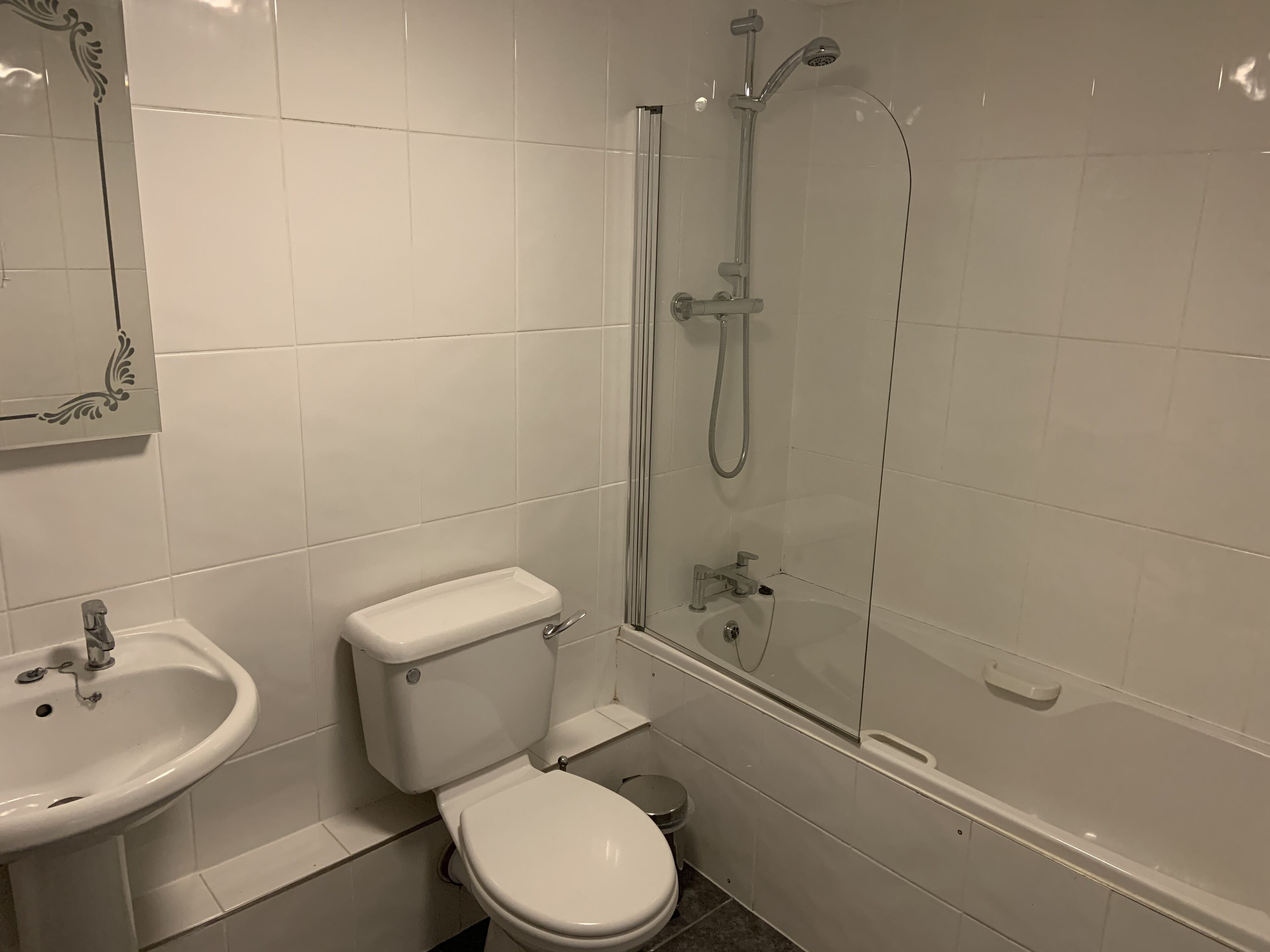 A bathroom with a toilet, sink, and glass-enclosed shower.