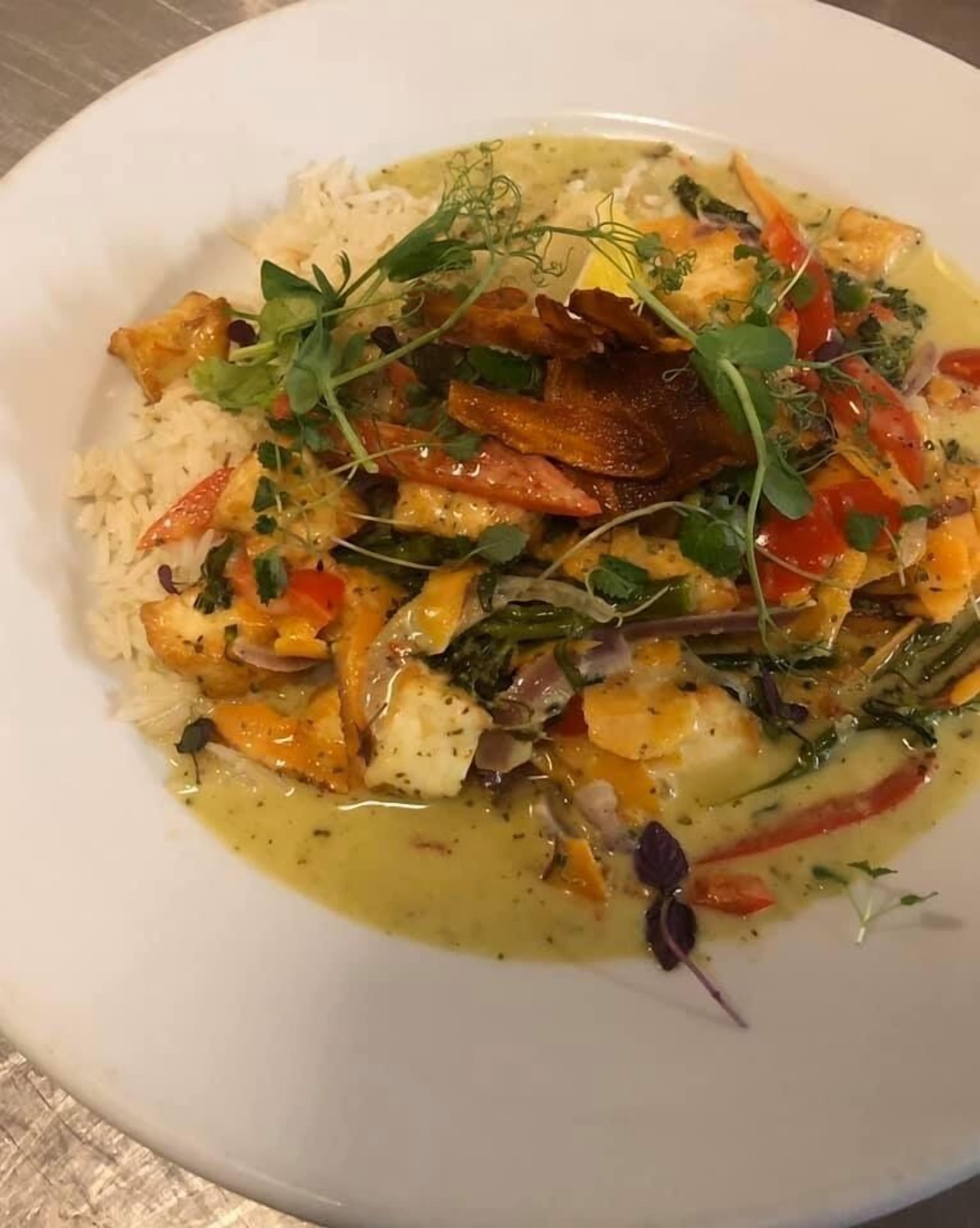 Plat de menjar amb arròs, verdures i herbes.