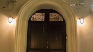A double door with a decorative archway and two wall-mounted lights.