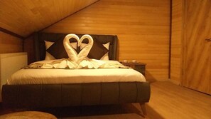 A bedroom with a bed featuring a heart-shaped pillow arrangement. - Dilek Suit & Cafe (Çaykara)