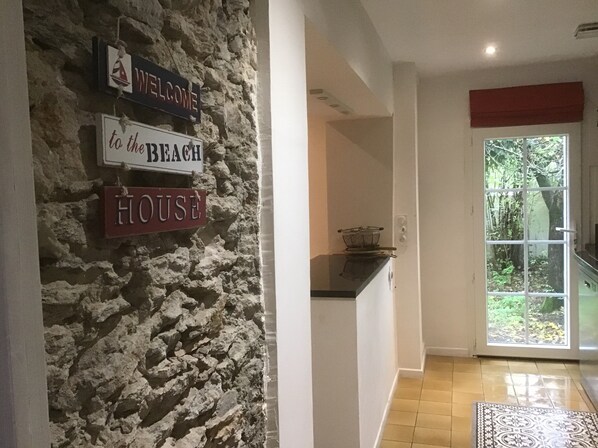 A stone wall with signs reading "Welcome to the Beach House."