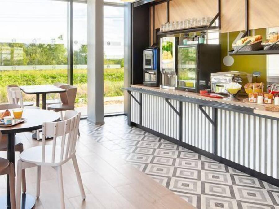 A modern outdoor café with a terrace, tables, chairs, and a counter with food and drinks.