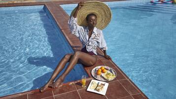 Een buitenzwembad en ligstoelen