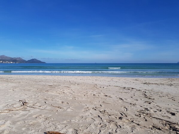 A sandy beach with footprints and a clear blue sky. - Apartment Alcudia Portobello with seaview (Puerto de Alcudia)
