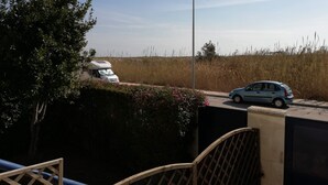 Ein weißer Wohnmobilwagen steht am Straßenrand, in der Nähe ein blaues Auto.
