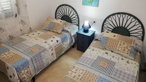Ein Schlafzimmer mit zwei Einzelbetten, einem Nachttisch mit Lampe und einem Bild an der Wand.