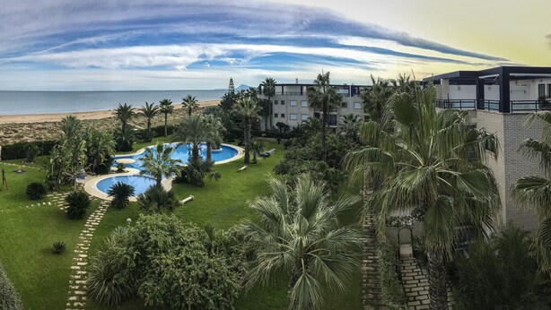 Ein Resort mit Pool, Palmen und Blick auf den Strand.