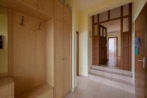 Un pasillo con puertas de madera y una escalera que lleva a otra habitación.