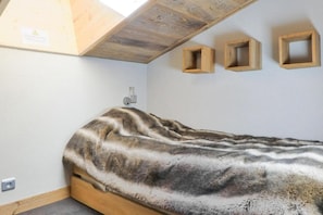 Cozy loft-style bedroom with a bed and ample storage.