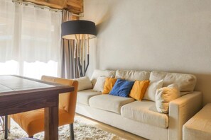 A living room with a sofa, a dining table, and a lamp.