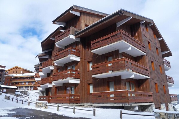 A multi-story wooden building with balconies, likely a hotel or resort.