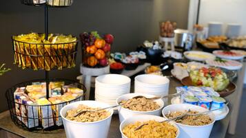 Un bufé con diversas opciones de comida, como cereales, frutas y sándwiches.