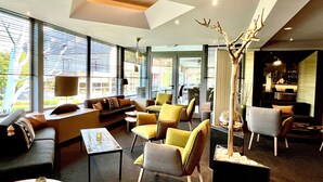 Un intérieur moderne avec un canapé, des fauteuils et une table basse.