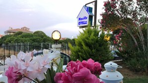 Una mesa con flores y un farol, un cartel que dice 'Mavi Ev OTE' y un farol de poste al fondo.