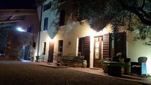 Ein zweistöckiges Gebäude mit Balkon, Esstisch und Stühlen außen.