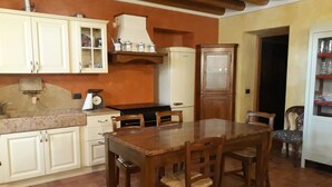 Eine Küche mit weißen Schränken, einem Holztisch und einem eingebauten Backofen.