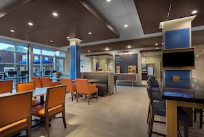Een modern café interieur met zitplaatsen, een koffiebar en uitzicht op buiten.