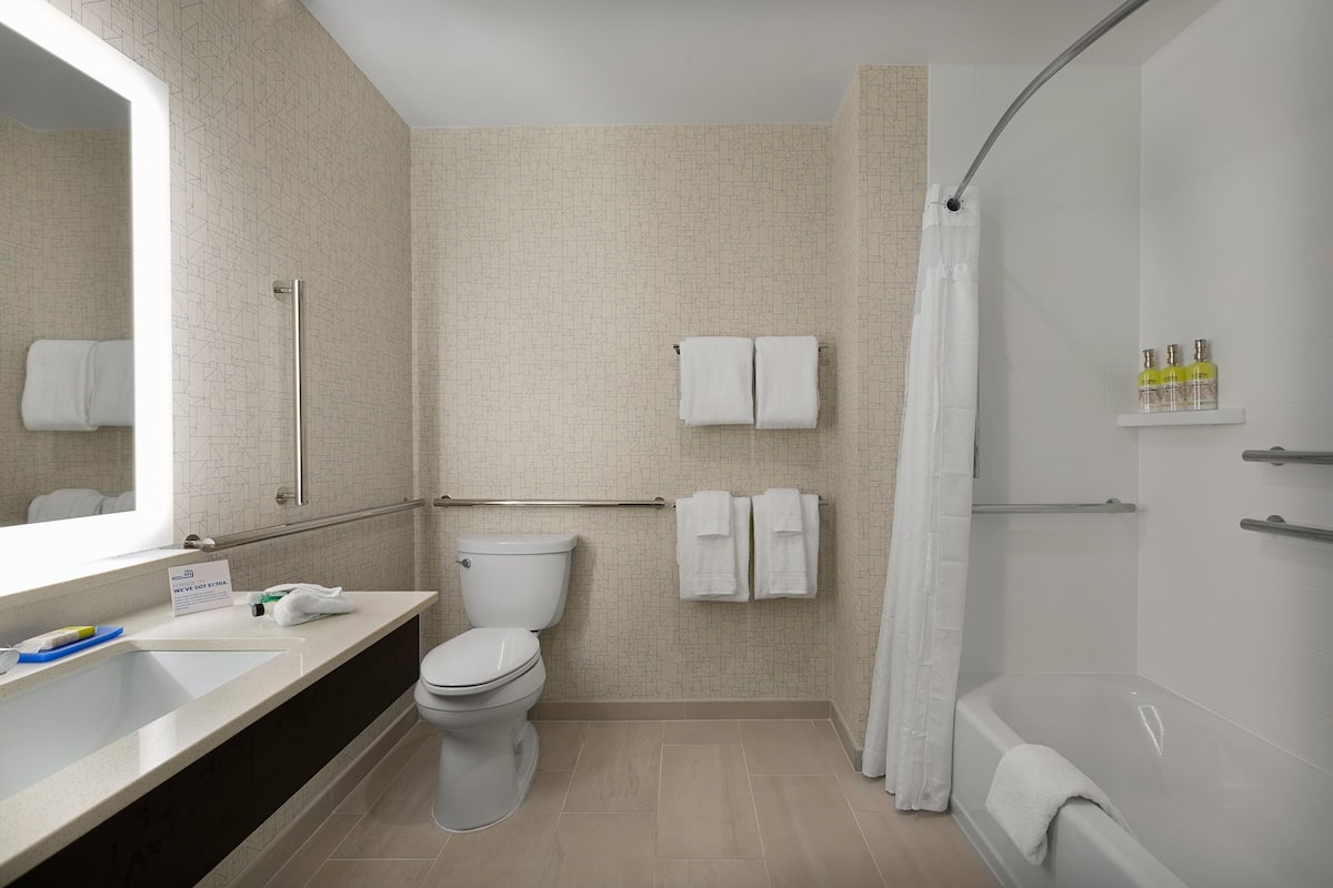 Une salle de bain moderne équipée d’une douche, de toilettes et d’un lavabo.