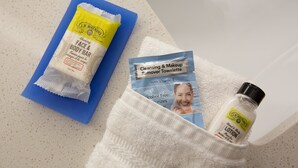 A bathroom with a blue towel, a white towel, and a bottle of lotion on the counter. - Holiday Inn Express & Suites Fayetteville South by IHG (Fayetteville)