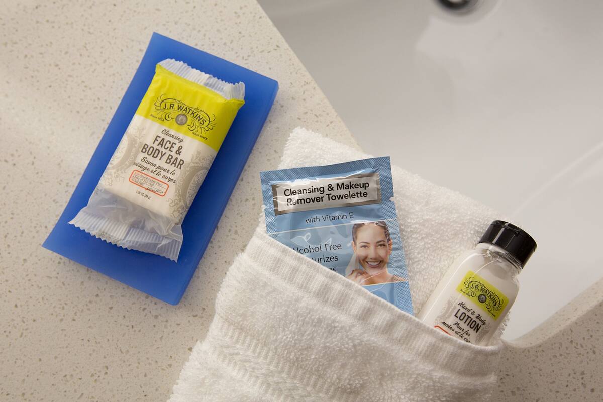 Une salle de bain avec une serviette bleue, une serviette blanche et un flacon de lotion sur le comptoir.
