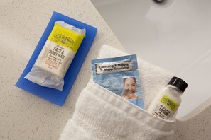 Une salle de bain avec une serviette bleue, une serviette blanche et un flacon de lotion sur le comptoir.