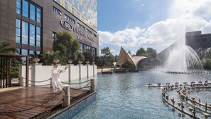 A hotel with a large fountain, a pool, and a modern building with a sign. - Crowne Plaza Deqing Moganshan by IHG (Huzhou)