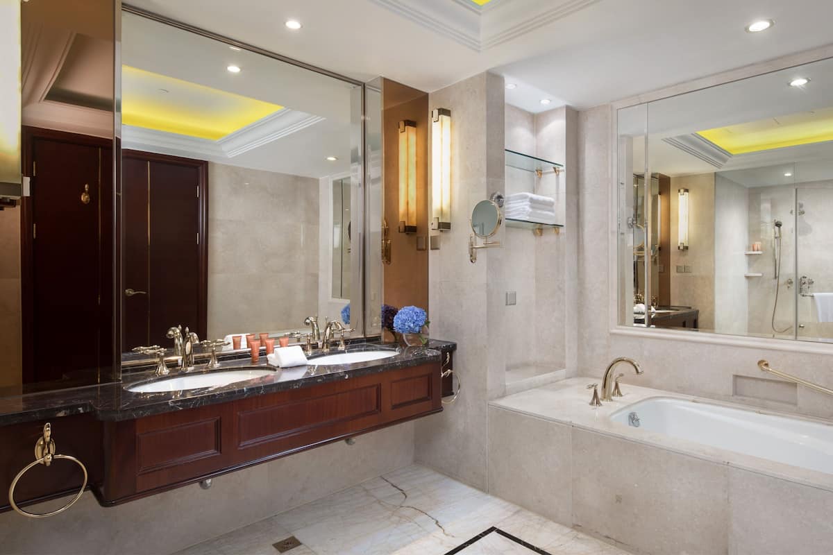 Un baño moderno con tocador doble, un espejo grande e hidromasaje separado.