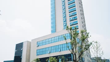 Um edifício moderno com uma estrutura vertical marcante e fachada plana.