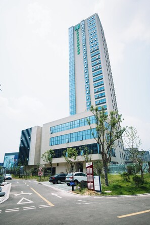 A modern building with a prominent vertical structure and a flat facade. - Holiday Inn Express Ningbo Fenghua by IHG (Ningbo)
