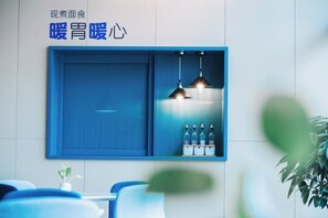A modern interior with a blue-framed wall-mounted shelf holding bottles and pendant lights. - Holiday Inn Express Ningbo Fenghua by IHG (Ningbo)