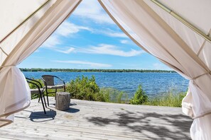 Un espace aménagé avec des tentes, offrant une vue sur un lac et une forêt.