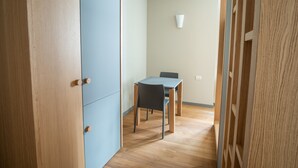 Une pièce avec un plancher en bois, un mur bleu et une table avec une chaise.