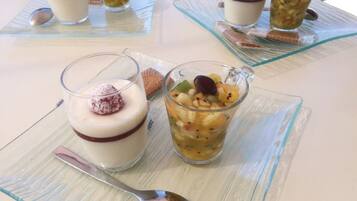 A table with three dessert glasses, each with a different dessert and a spoon.