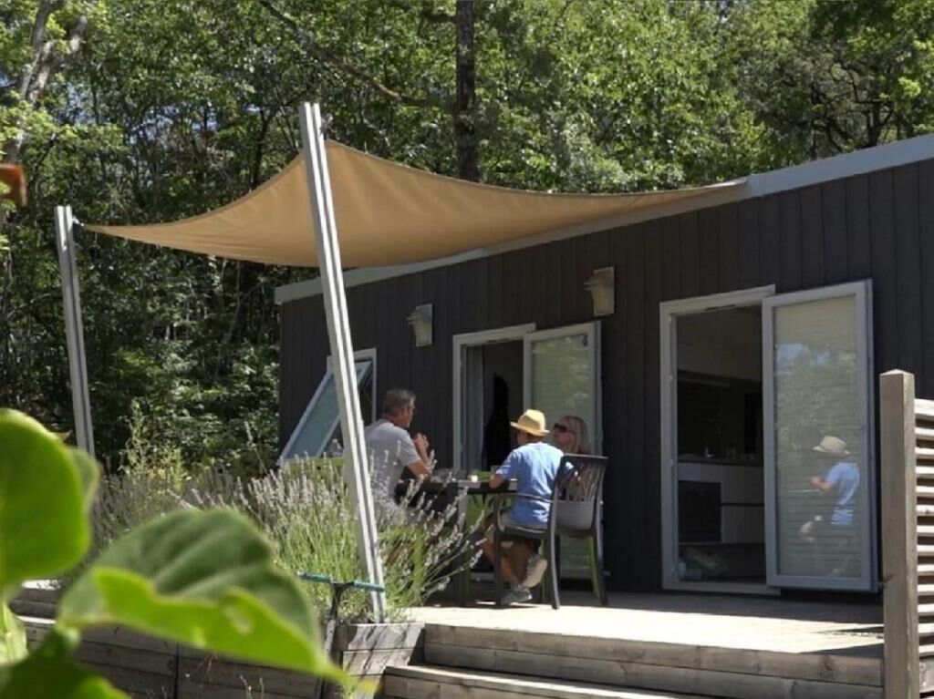 A building with a covered patio area, a large window, and a door.