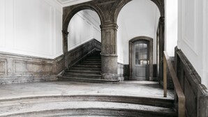 A grand staircase with marble steps and stone columns, leading to a door at the top. - Majestic 300m2 Apartment (Copenhagen)