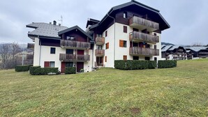 A multi-story building with balconies, a flat roof, and a grassy lawn. - Cozy 1-Bedroom Apt in Bernex - Ski-In/Ski-Out, WiFi, Pet-Friendly, Near Evian & Lake Geneva (Bernex)