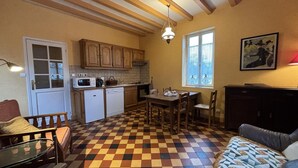 Una cocina acogedora con armarios de madera, una mesa de comedor y suelo de cuadros.