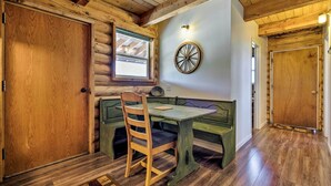 A wooden interior with a bench and table, a wooden door, and a window with a view. - Pet-Friendly Moab Cabin w/ Mtn Views & BBQ! (Moab)