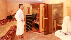 Una sala de sauna con un banco de madera, un banco con una toalla y la puerta de la sauna.