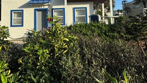 A multi-story building with a balcony on the second floor, a door with a blue frame, and a number '103' on the facade. - Beachside House with 2 Floors (Jacksonville Beach)