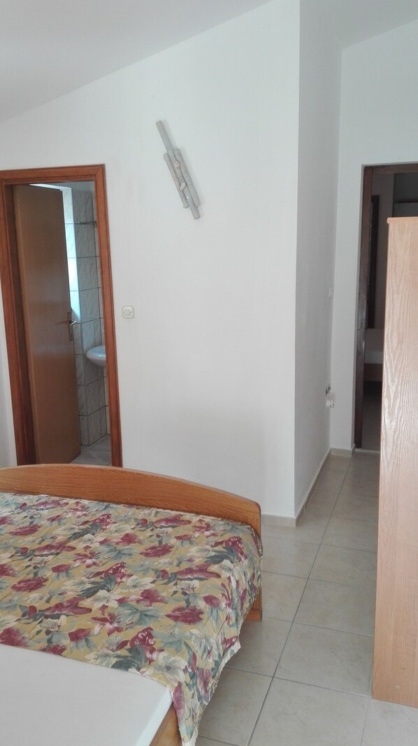 A bedroom with a bed, a door, and a light fixture.