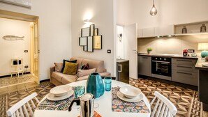 Un espacio habitable compacto con comedor, kitchenette y sofá.