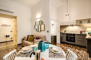 Un espacio habitable compacto con comedor, kitchenette y sofá.