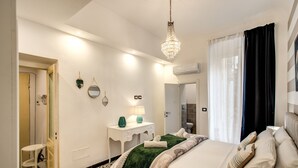 Un dormitorio moderno con cama, mesita de noche y una araña.