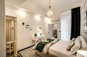 Un dormitorio moderno con cama, mesita de noche y una araña.