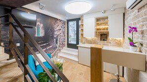 Une cuisine moderne avec un mur en pierre, un four encastré et une fenêtre offrant une belle vue.