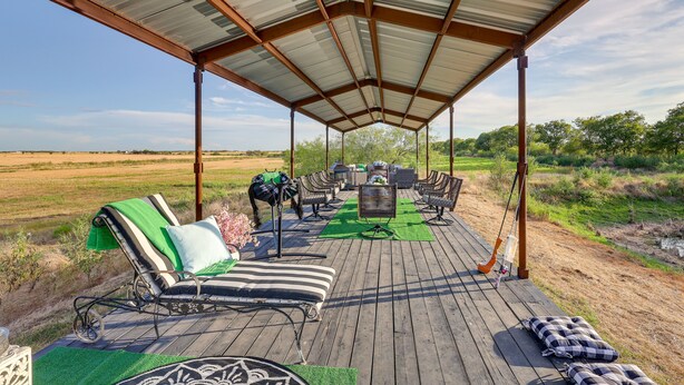 A covered outdoor seating area with lounge chairs and a table, surrounded by a natural landscape. - Retreat w/ Pond Access & Views in Temple (Temple)