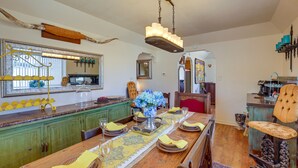 A dining area with a wooden table set for a meal, a chandelier, and a mirror above the counter. - Retreat w/ Pond Access & Views in Temple (Temple)