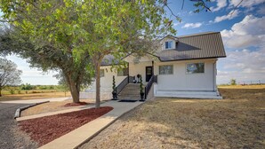 A two-story house with a front porch, a tree in front, and a clear sky. - Retreat w/ Pond Access & Views in Temple (Temple)