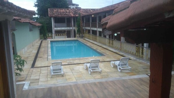 Alberca al aire libre y camastros